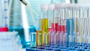 Beakers being filled with multi-colored liquids in a laboratory