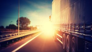 A truck hauling goods into the sunset