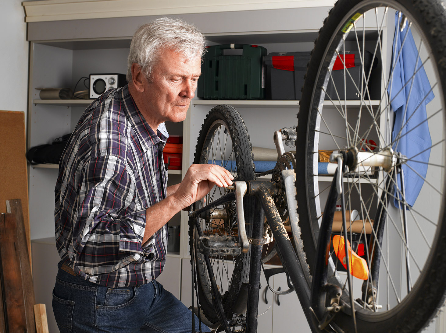 Silver-haired man fixing a bicycle