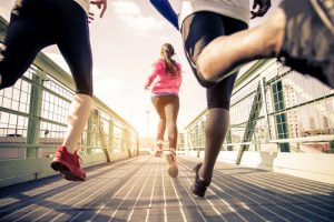 Runners crossing a metal bridge