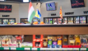 Flags of European nations atop a grocery display case in a travel center